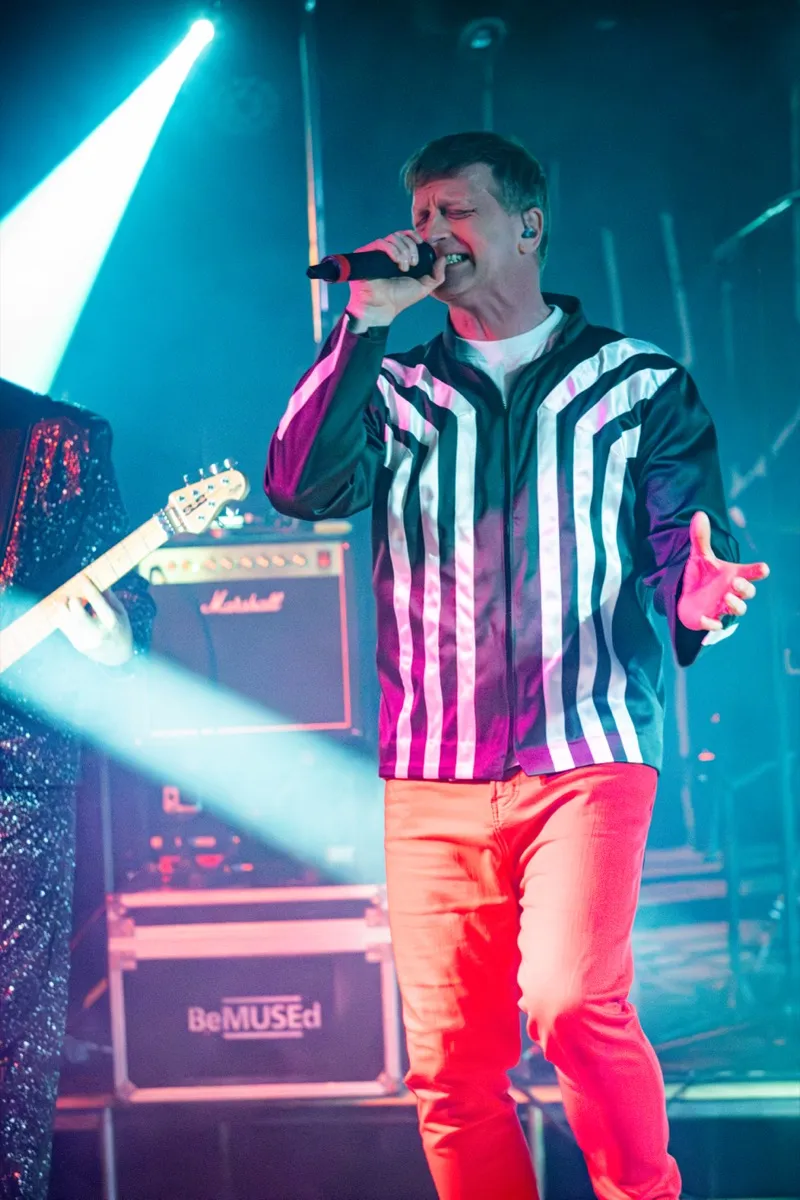 Vocalist singing with BeMUSEd flight case and Marshall amp visible